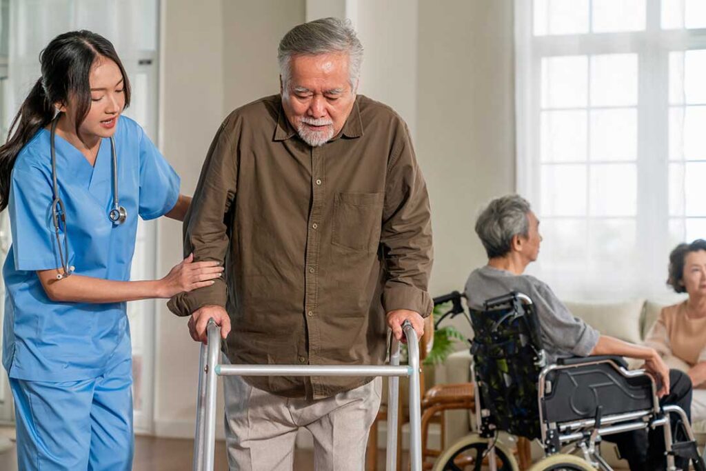 Two older adults and a younger family member packing personal items and clothing into boxes in a cozy bedroom setting.