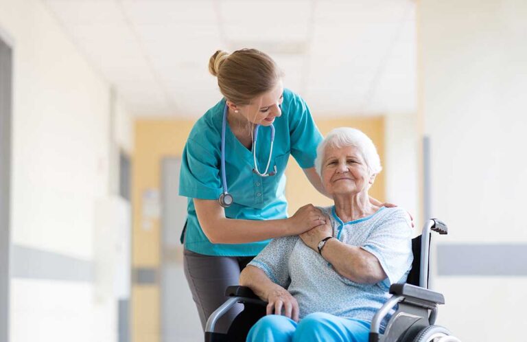 A nurse assisting an elderly resident with medication in a sunny, comfortable living space.